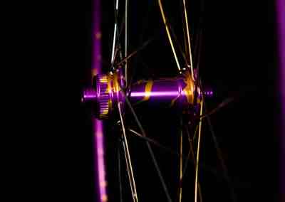 Custom purple and gold splatter anodized bike wheel